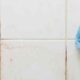 person cleaning bathroom tile